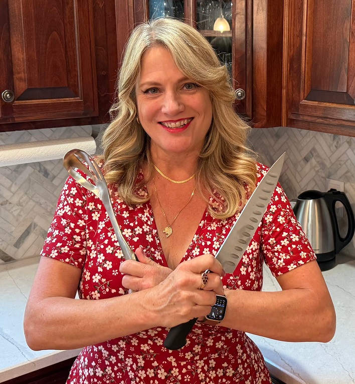 Erin Cormier, founder of Cream & Cloves, in her kitchen holding a chef's knife and spoon.