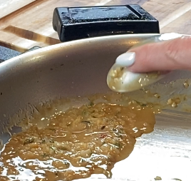 Testing pan sauce thickness by coating the back of a spoon