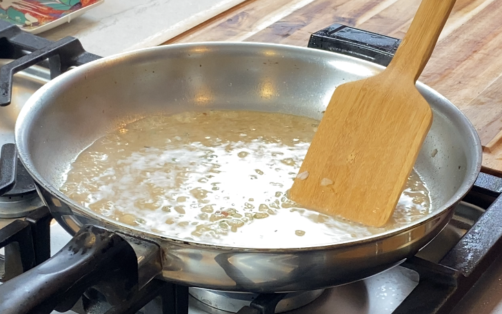 Pan sauce simmering and reducing to concentrate flavor