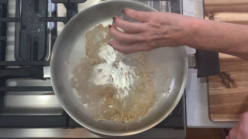 Deglazing the pan with white wine to build a pan sauce