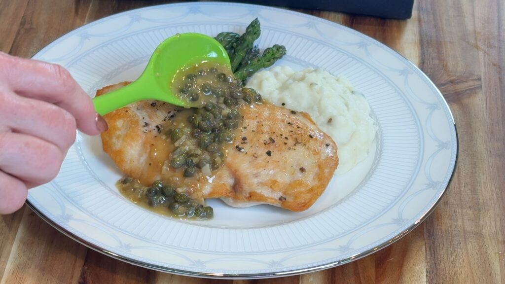 Lemon caper pan sauce spooned over chicken and mashed potatoes