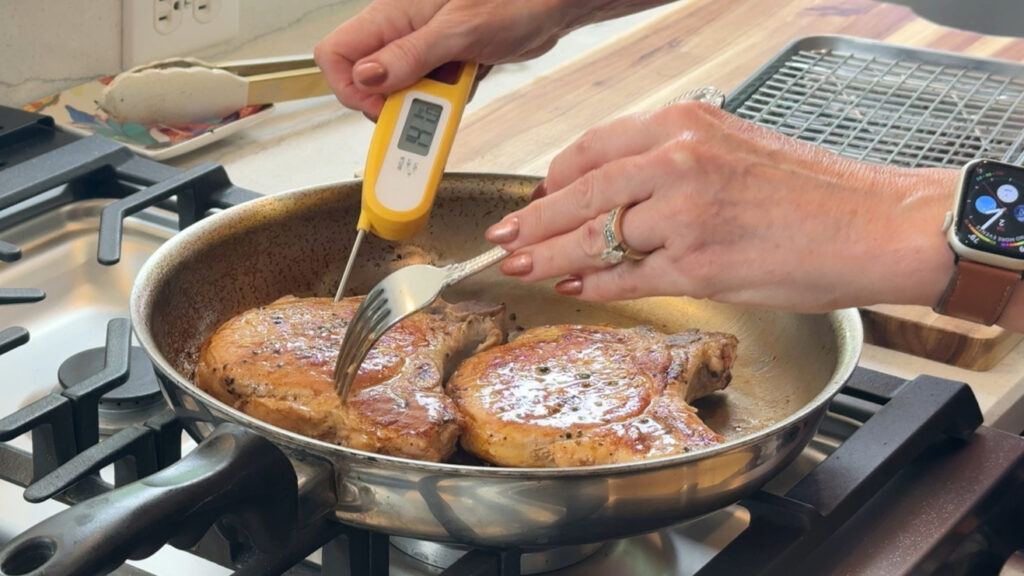 Checking the internal temperature of a pork chop with an instant-read thermometer