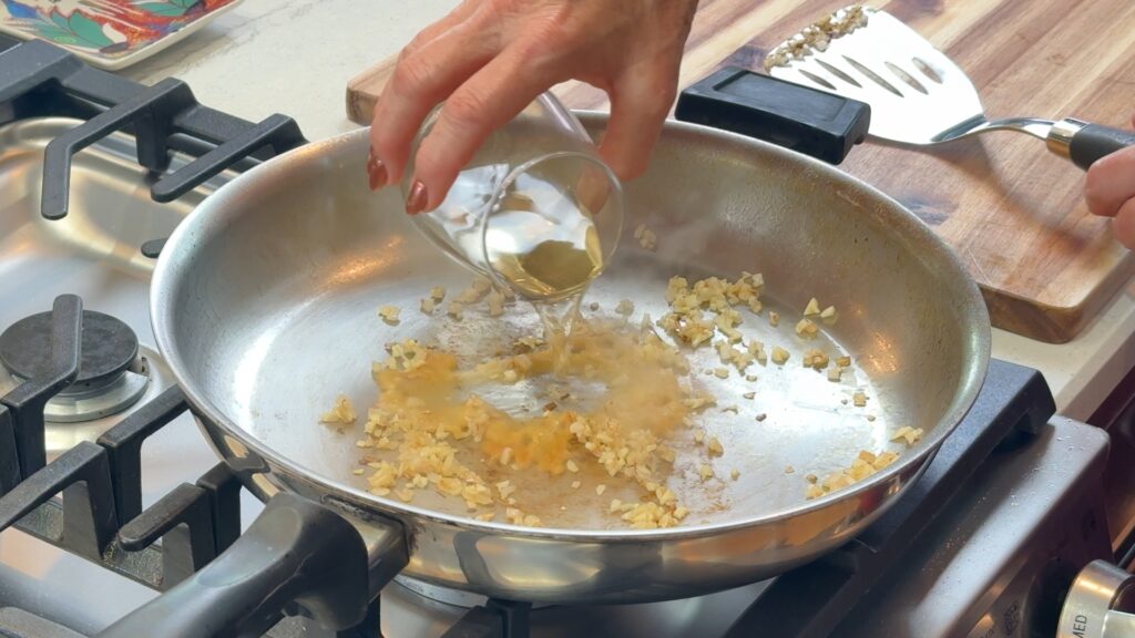 Deglazing the pan with white wine for mustard cream pan sauce