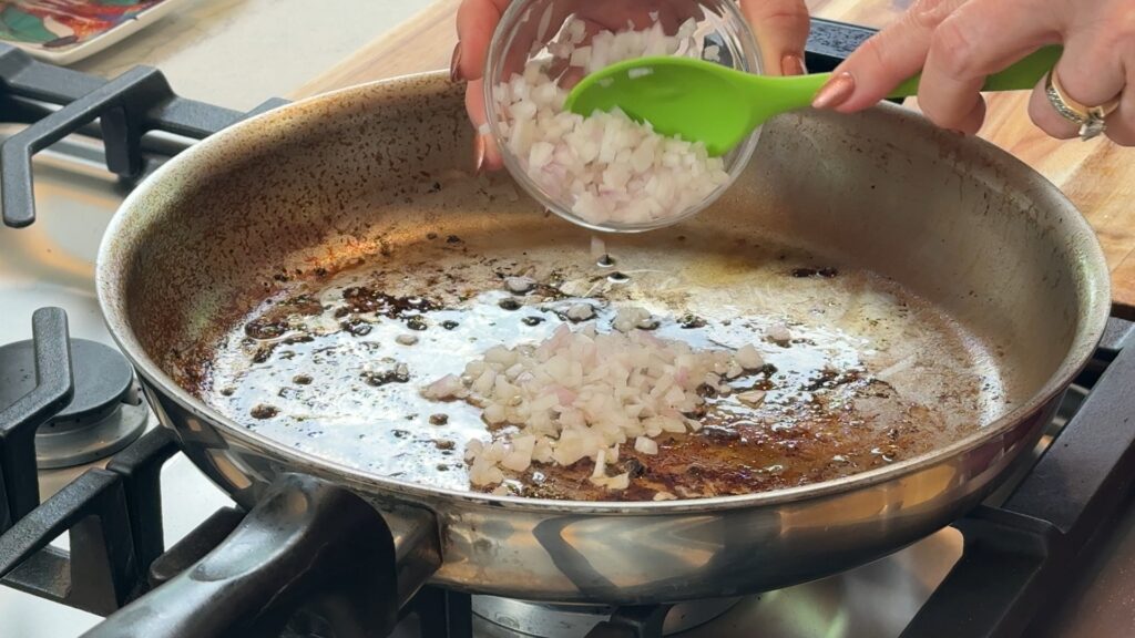 Minced shallots softening in the fond