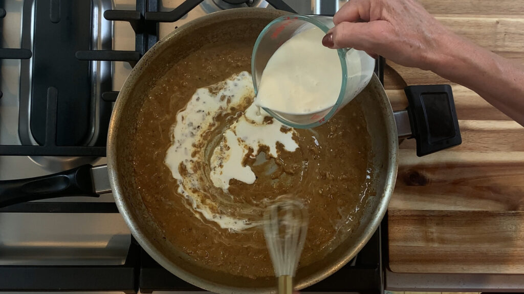 Pouring heavy cream into the mustard cream pan sauce