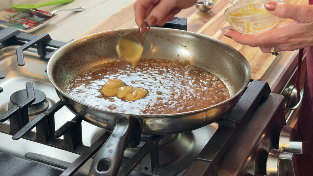 Adding mustard into the reduced sauce