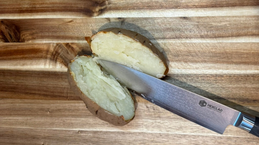 Baked potatoes being cut open to release the steam. 