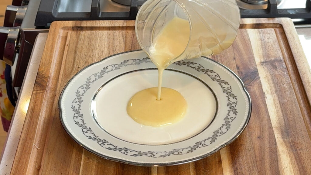 Beurre blanc sauce being poured onto a white plate