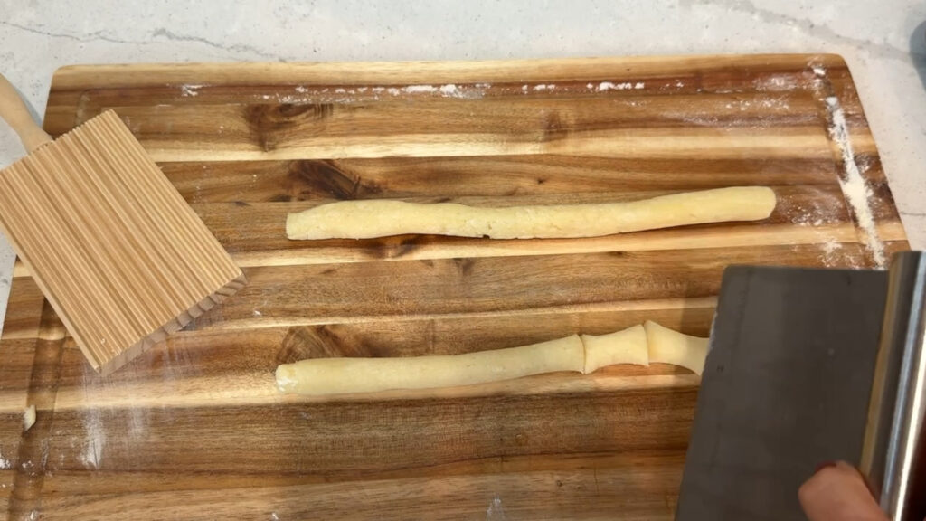 Cutting rolled gnocchi.