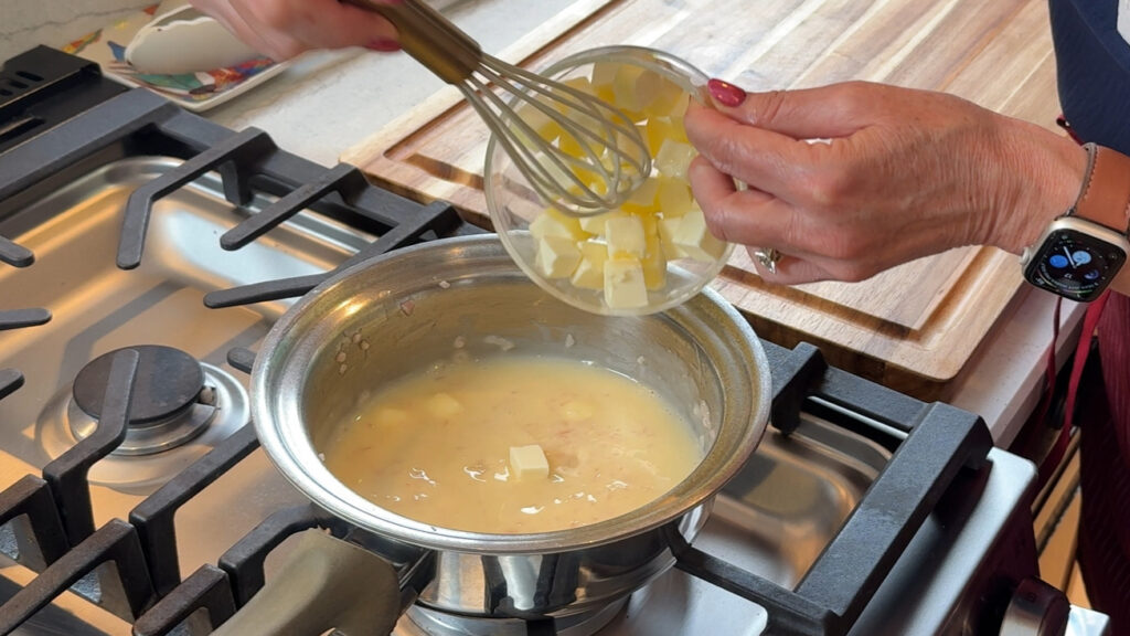 Whisking cold cubed butter into a beurre blanc reduction over low heat