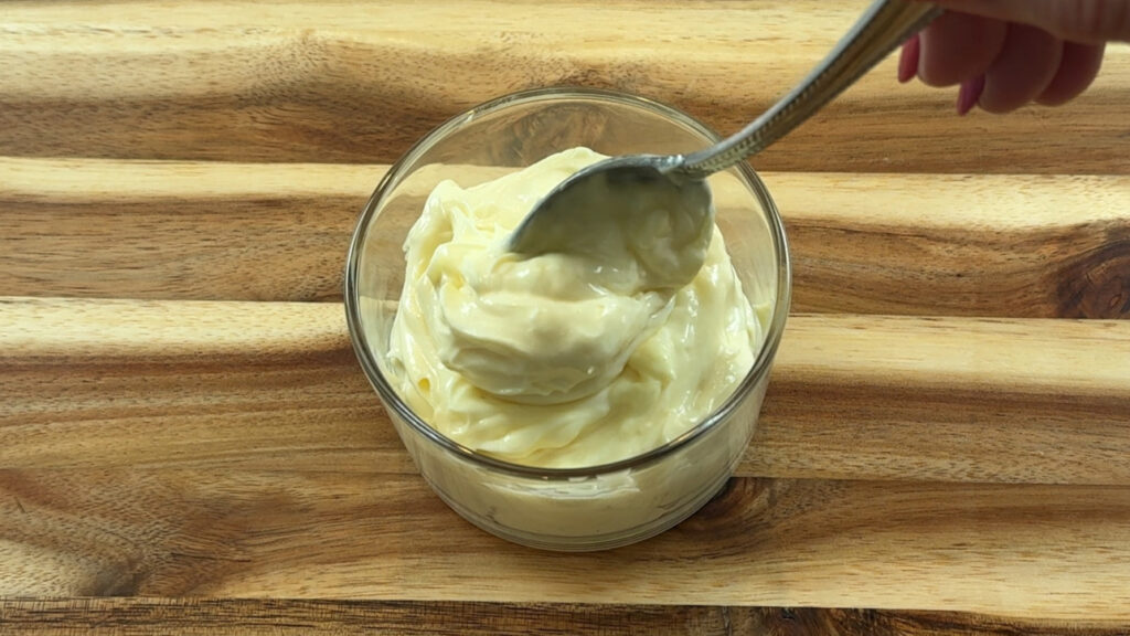 Finished mayo, glossy on a spoon.