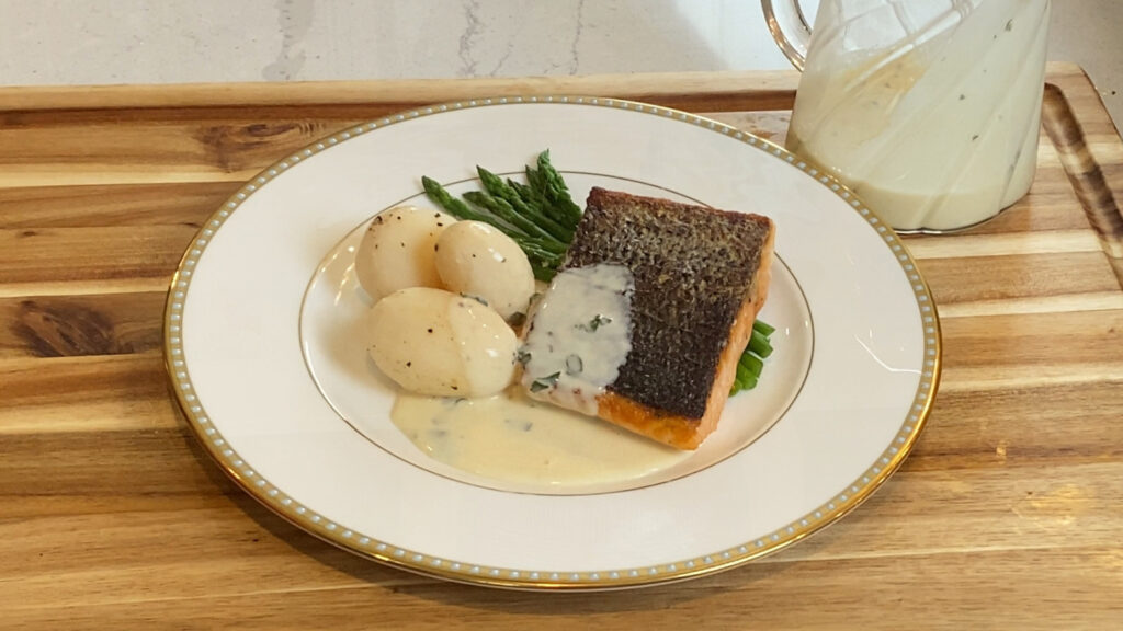 Plate of salmon with Sandefjordsmør sauce, potatoes, and asparagus.
